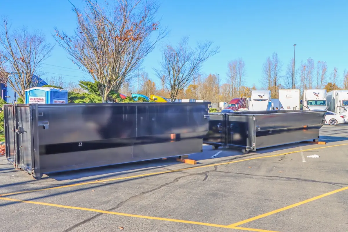 Professional dumpster rental service with roll-off container on residential driveway in Eastman